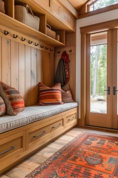 a wooden bench sitting in front of a window next to a rug on top of a hard wood floor