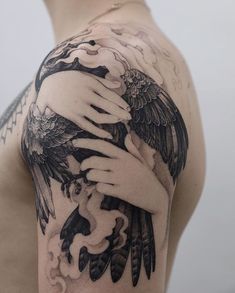 a man with a tattoo on his arm holding a bird