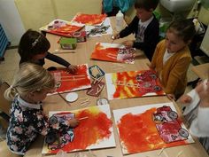 several children are sitting at a table making art with paper plates and watercolors