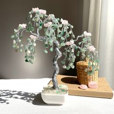 a bonsai tree sitting on top of a table next to a basket