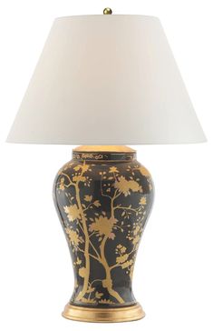 a black and gold vase lamp with a white shade on the top, in front of a white background