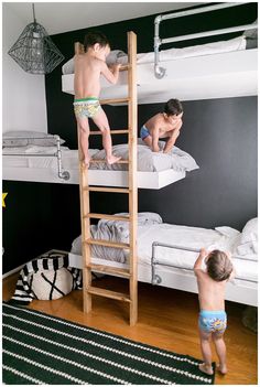 two young boys are climbing on bunk beds