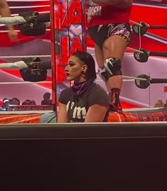 the woman is standing on top of the wrestling ring