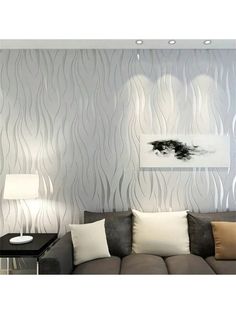 a modern living room with white and grey wallpaper, couches and lamps in the corner