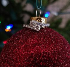 a red ornament with two wedding rings on it