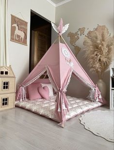 a pink teepee tent sitting on top of a wooden floor