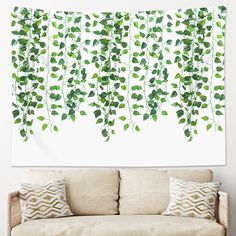 a wall hanging over a couch covered in green leaves