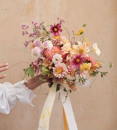 a woman holding a bouquet of flowers in her hand