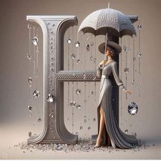 a woman holding an umbrella standing next to the letter e with diamonds all over it