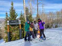 four skiers pose for a photo at the top of a mountain