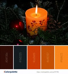 an orange candle sitting on top of a christmas tree