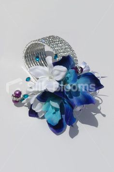 a hair comb with flowers and pearls on it's side, sitting on a white surface