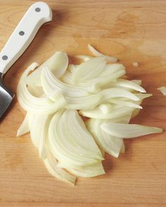 chopped onions on a cutting board next to a knife