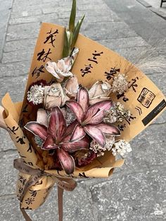 a bouquet of flowers is wrapped in brown paper