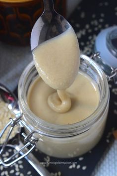 a spoon is lifting some food out of a jar