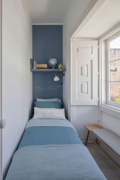 a small bedroom with a bed and shelves on the wall