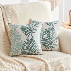 two blue and white pillows on a couch