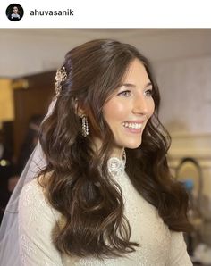 a woman with long hair wearing a wedding dress and tiara smiling at the camera