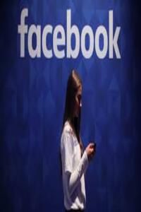 a woman standing in front of a facebook sign