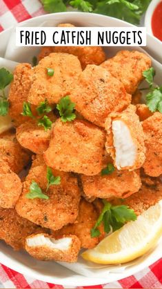 a white bowl filled with fried chicken nuggies next to a red and white checkered tablecloth