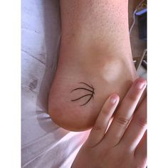 a woman's foot with a small tree tattoo on her left side and an arrow in the middle