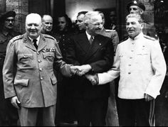 black and white photograph of two men shaking hands with other men in uniform behind them