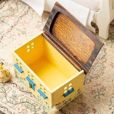 an open wooden box sitting on top of a rug next to a stuffed animal toy