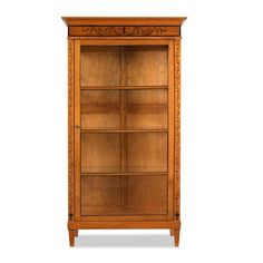 a wooden bookcase with glass doors and carvings on the front, in an oak finish