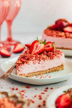 two slices of cheesecake with strawberries on the top and one slice cut in half