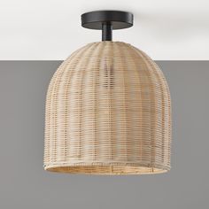 the light fixture is made out of wicker and has a black metal rod on top