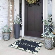 a welcome mat on the front porch with potted plants