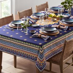 a dining table set with place settings and plates