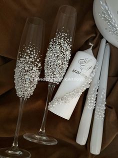 two champagne flutes, one with pearls and the other decorated with swaronks