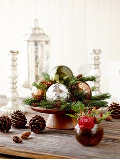 a wooden table topped with pine cones and ornaments