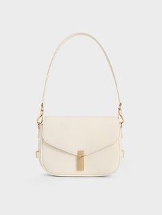 In elegant and sophisticated cream, this Aurelia saddle bag makes a subtle statement while still being incredibly versatile. Featuring a timeless silhouette, this polished carrier stands out with its distinctive gold-tone hardware. A chic turn-lock closure -- taking the form of a narrow vertical bar -- is the striking centrepiece of this design. This bag also comes with an adjustable strap that you can clip on easily to transform it into a handy crossbody bag. Purse Png, Cream Purse, Vertical Bar, Beautiful Handbags, Charles Keith, Saddle Bag, Metallic Accents, Saddle Bags, Clip On