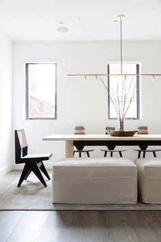 a modern dining room with white walls and wood flooring