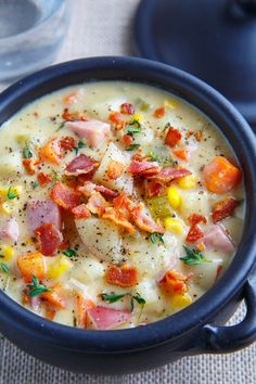 a close up of a bowl of soup with ham and corn