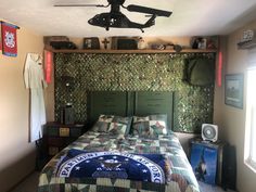 a bedroom with an army themed bed and ceiling fan