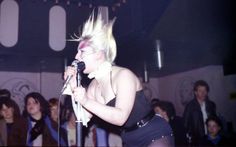 a woman with blonde hair singing into a microphone