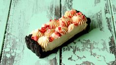 a piece of cake with cream and strawberries on it sitting on a wooden table