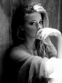 black and white photograph of a woman leaning against a wall