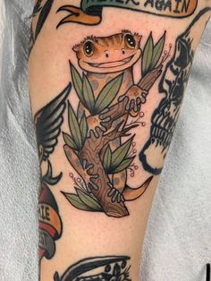 an arm with some tattoos on it and a lizard sitting on top of a tree branch