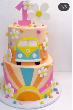 a birthday cake with a bus and flowers on it's top tier is decorated in pastel colors