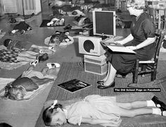 an old black and white photo of children laying on the floor in front of computers