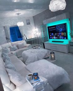 a living room filled with white furniture and a flat screen tv mounted to the wall