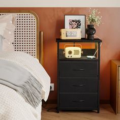 a bedroom with an alarm clock on the nightstand next to a bed and night stand