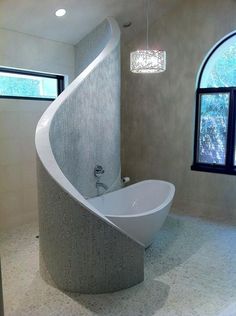 a bathroom with a curved bathtub next to a window