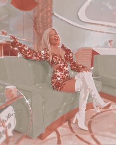 a woman sitting on top of a couch in a living room next to a guitar