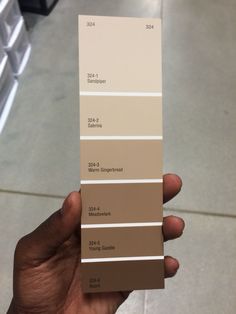 a hand holding a pantone color swatch in the middle of a store floor