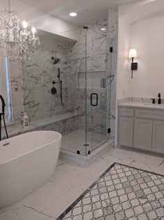 a bathroom with a tub, sink and chandelier